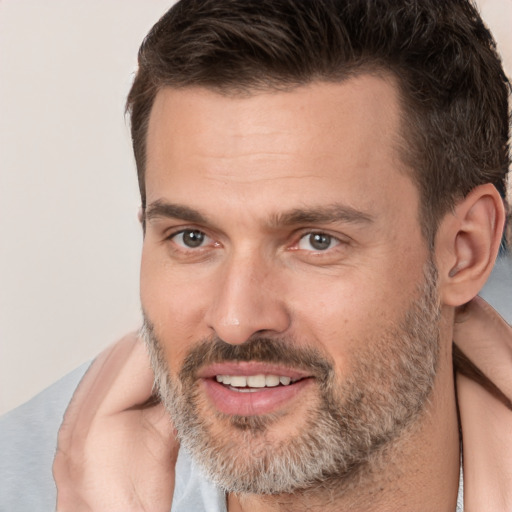 Joyful white adult male with short  brown hair and brown eyes