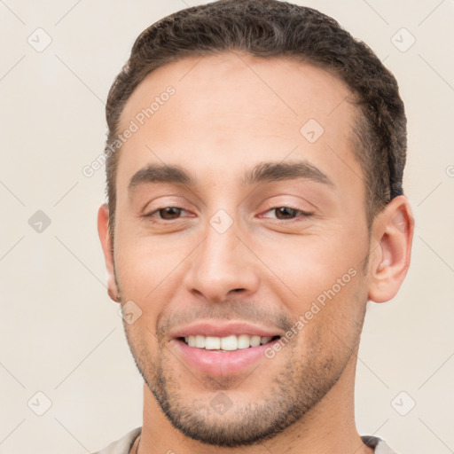 Joyful white young-adult male with short  brown hair and brown eyes