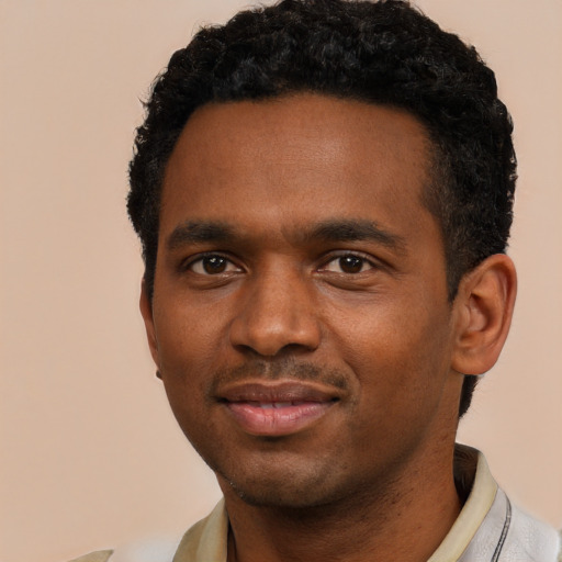 Joyful black young-adult male with short  black hair and brown eyes