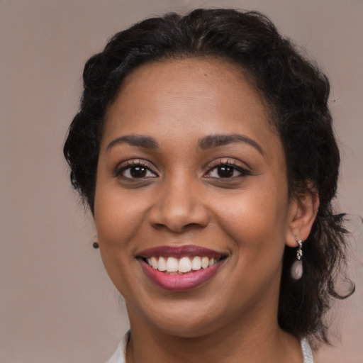 Joyful black young-adult female with long  brown hair and brown eyes