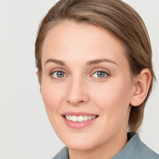 Joyful white young-adult female with medium  brown hair and blue eyes