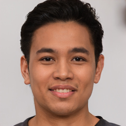 Joyful latino young-adult male with short  brown hair and brown eyes