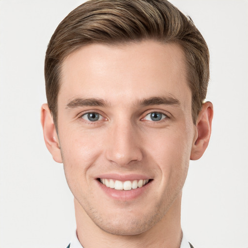 Joyful white young-adult male with short  brown hair and grey eyes