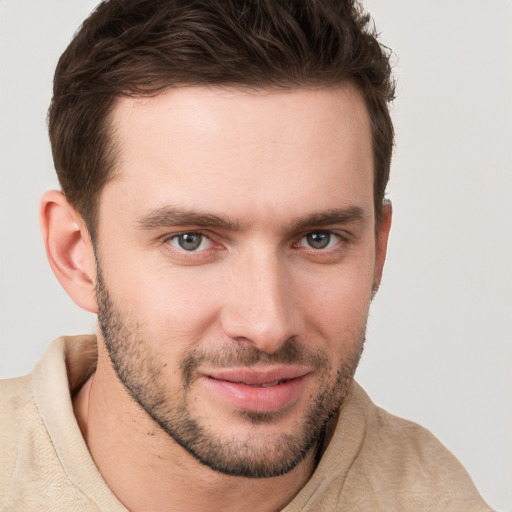 Joyful white young-adult male with short  brown hair and grey eyes