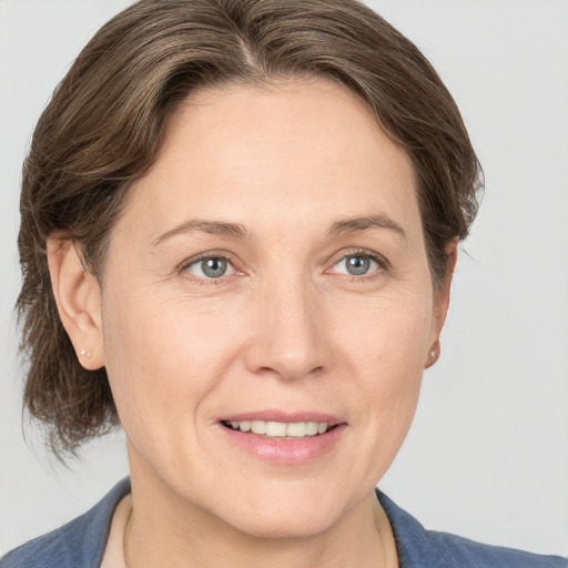 Joyful white adult female with medium  brown hair and grey eyes