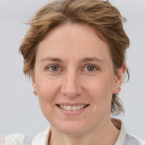 Joyful white adult female with medium  brown hair and grey eyes