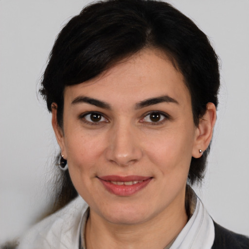 Joyful latino young-adult female with medium  brown hair and brown eyes