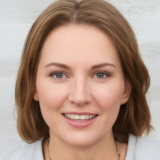 Joyful white young-adult female with medium  brown hair and blue eyes