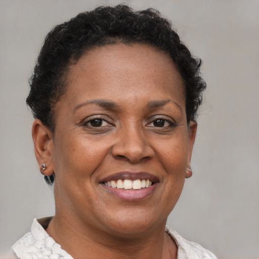 Joyful black adult female with short  brown hair and brown eyes