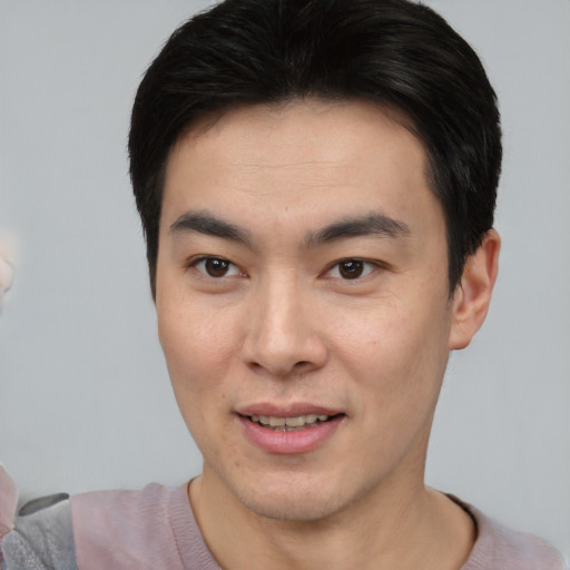 Joyful asian young-adult male with short  brown hair and brown eyes