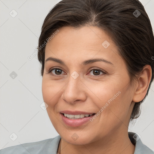 Joyful white adult female with medium  brown hair and brown eyes