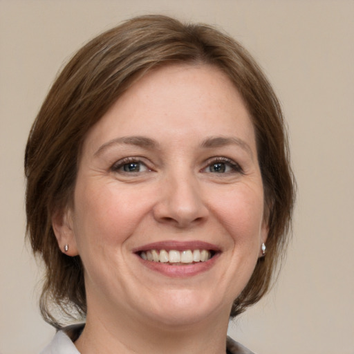 Joyful white adult female with medium  brown hair and grey eyes