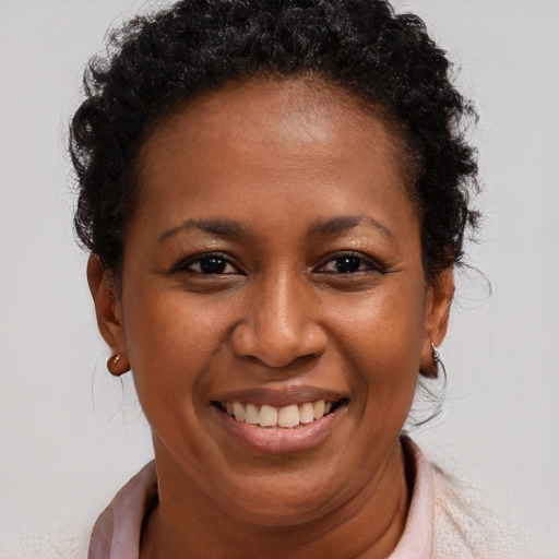 Joyful black adult female with short  brown hair and brown eyes