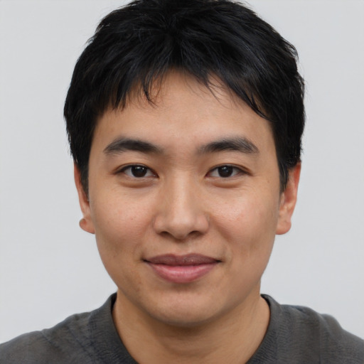 Joyful asian young-adult male with short  black hair and brown eyes