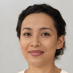 Joyful latino adult female with medium  brown hair and brown eyes