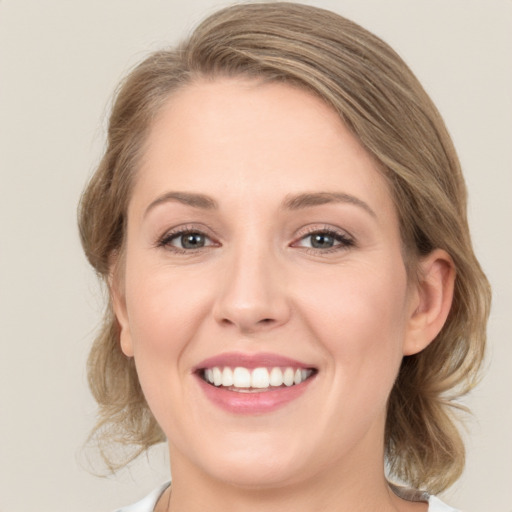 Joyful white young-adult female with medium  brown hair and blue eyes