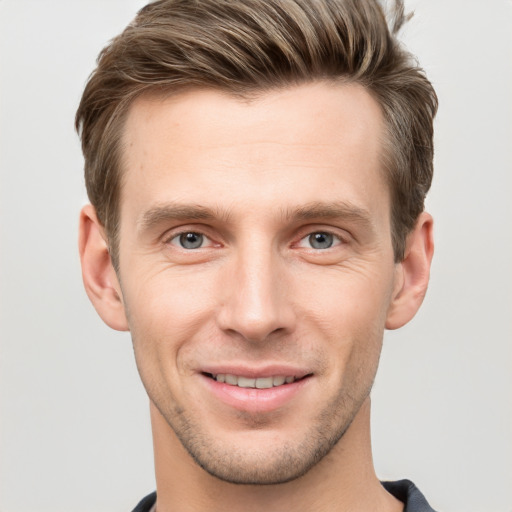 Joyful white young-adult male with short  brown hair and grey eyes