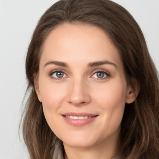 Joyful white young-adult female with long  brown hair and grey eyes