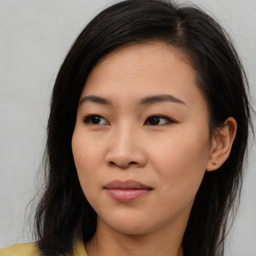 Joyful asian young-adult female with long  brown hair and brown eyes