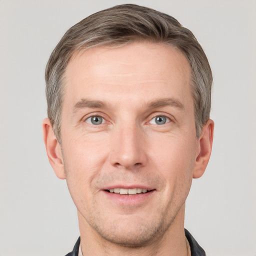 Joyful white adult male with short  brown hair and grey eyes