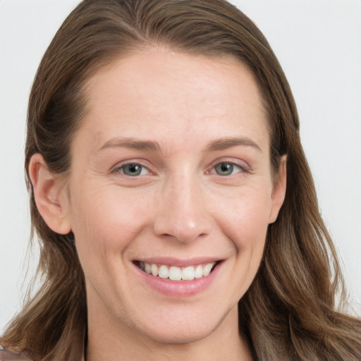 Joyful white young-adult female with long  brown hair and grey eyes