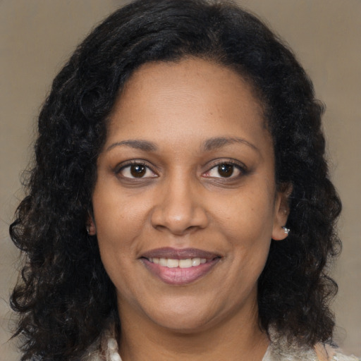 Joyful black adult female with long  brown hair and brown eyes